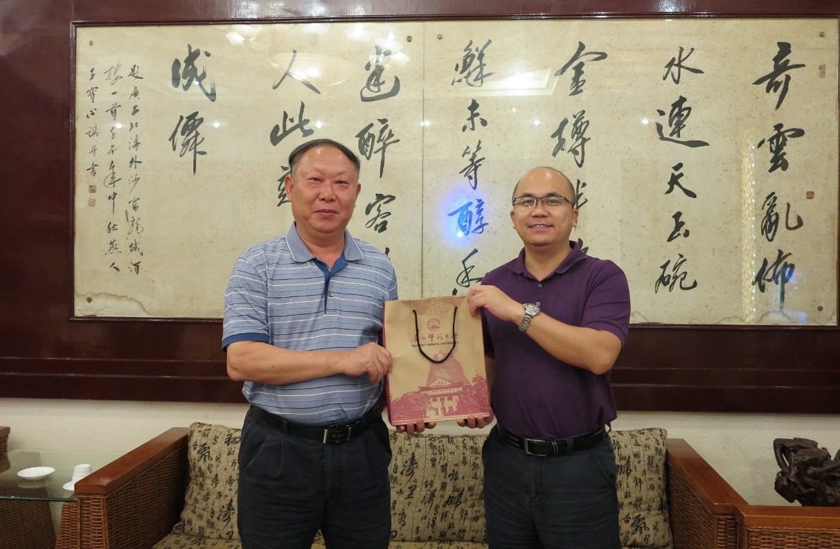 校领导刘健斌向校友代表北海市委常委、宣传部部长、副市长谢向阳赠送校庆宣传片和校庆丛书