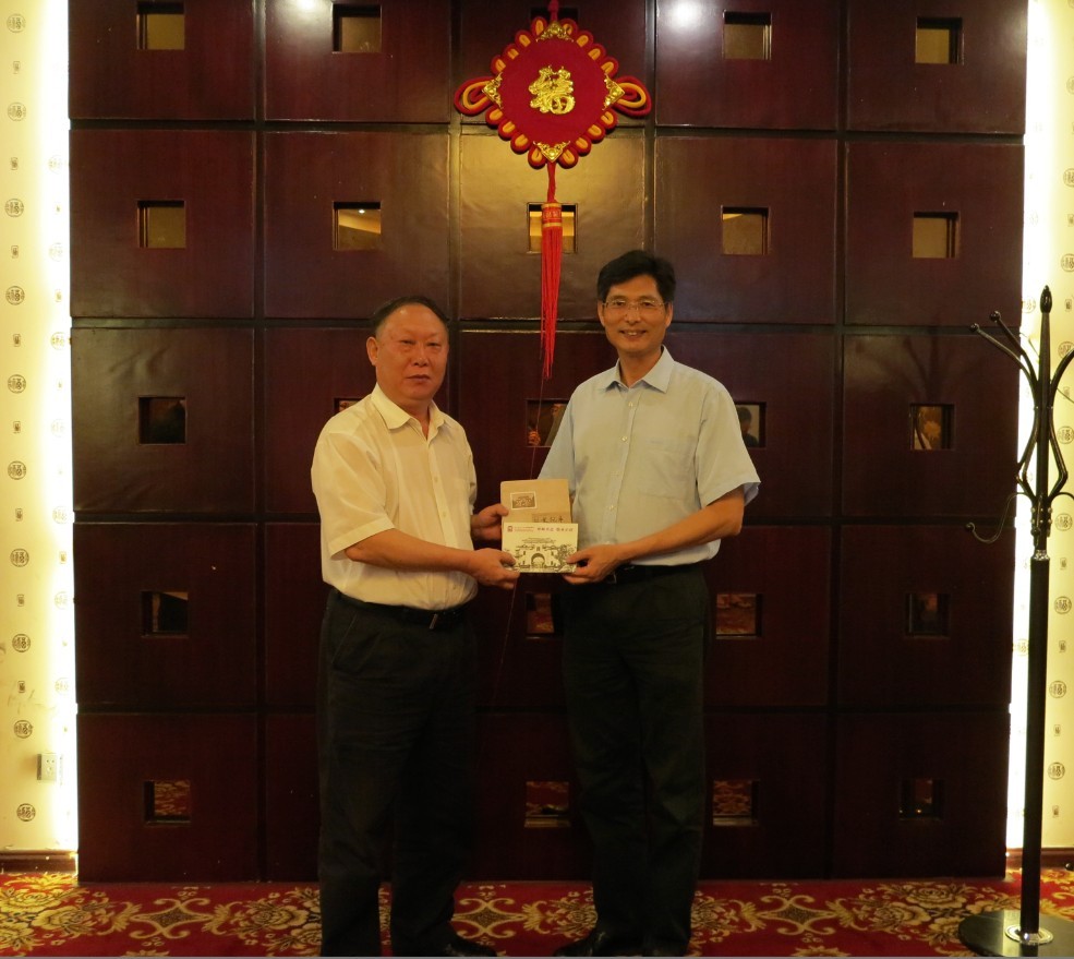 校领导刘健斌向校友代表防城港市政协主席赵发旗赠送校庆宣传片和校庆丛书