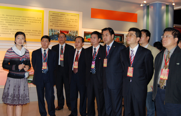 讲解员向专家们介绍我校本科办学成就展。