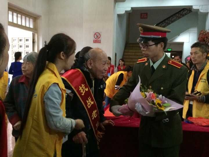 志愿者为抗战老兵鲜花，披绶带（摄影　牟芝颖）