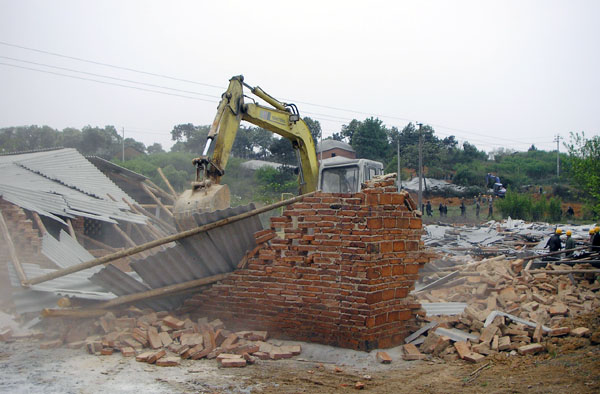 挖掘机正在拆除我校雁山校区三期建设用地上抢搭的违章建筑。