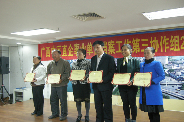 档案馆负责人领取我校获得的2012年文件材料归档质量优秀单位荣誉证书