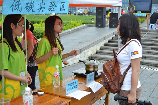 环境与资源学院学生向市民解释“沸水余温如何煮熟鸡蛋”（大学生通讯社 梁礼曾 摄）