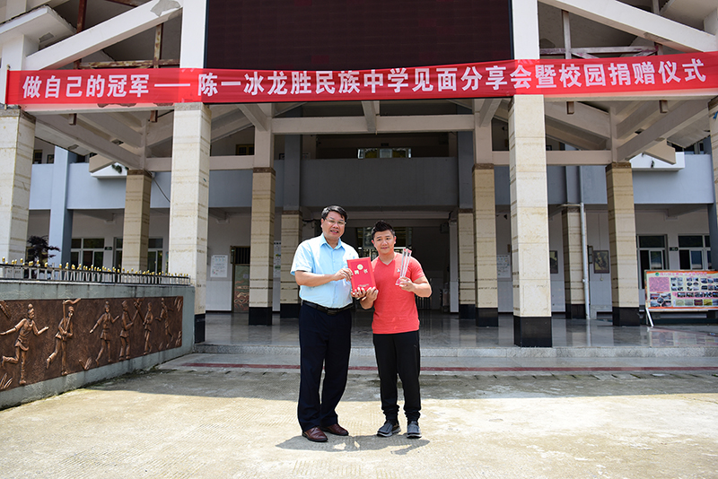 广西师范大学出版社集团党委书记、董事长张艺兵为陈一冰颁发“广西师范大学出版社公益形象大使”聘书及水晶杯（李显杨摄）.JPG
