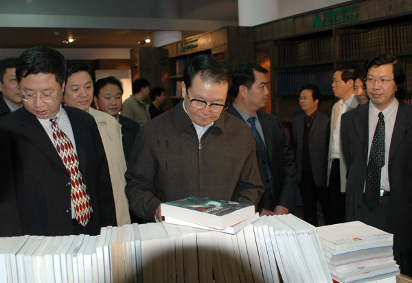 李长春认真察看出版社出版的图书。