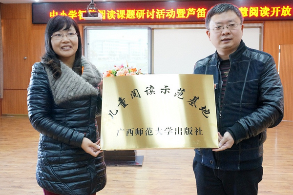 桂林市芦笛小学陈海荣校长接受广西师范大学出版社“儿童阅读示范基地”授牌 （欧惠兰摄）