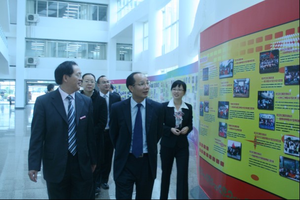 唐仁郭副书记（左一）陪同团区委李泽书记（左二）观看图片展