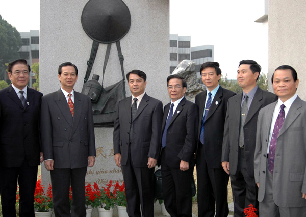 来宾与我校领导在育才校区中越友好纪念碑前合影。