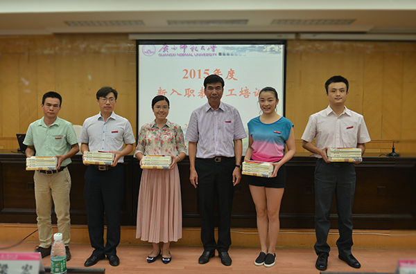 校长梁宏向新教师代表赠送《广西师范大学章程》、《教师师德手册》、《魅力教师》等书籍