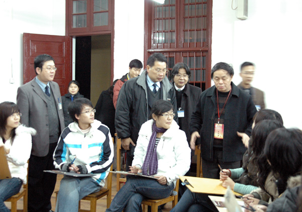 评估专家翁振新教授（后排右一）在对学生进行人物速写测试。