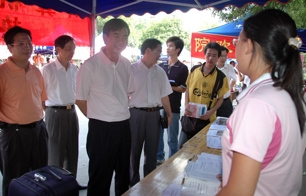 梁宏校长一行在报到点询问迎接新生工作的布置情况。