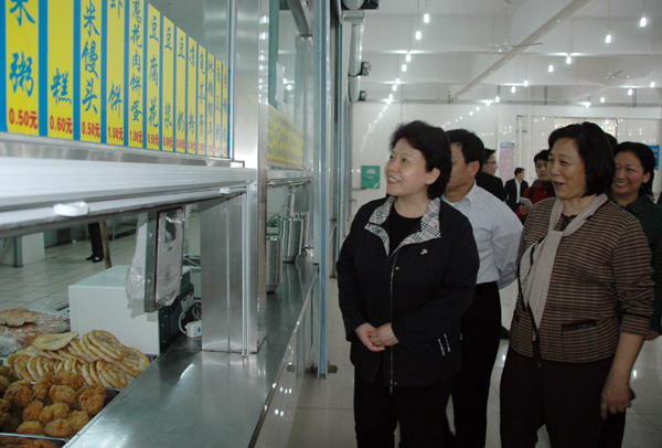 李康副主席（左一）考察学生食堂。