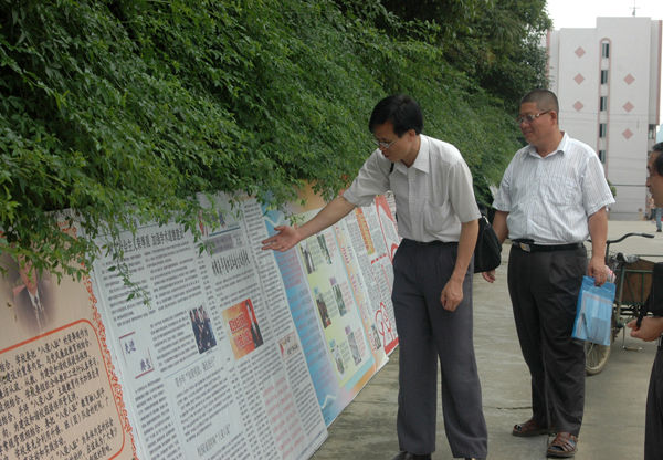 督查组实地察看我校学生学习社会主义荣辱观板报，并肯定了板报的出版质量。