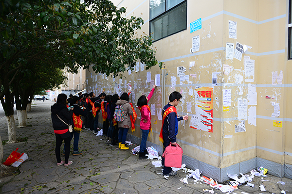 志愿者们清理校园小广告（韦一琦 摄）