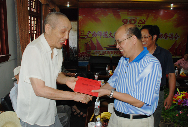 蔡昌卓副校长（右）给离休干部发慰问金