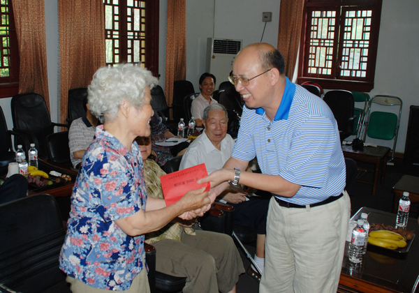 蔡昌卓副校长（右）给离休干部发慰问金