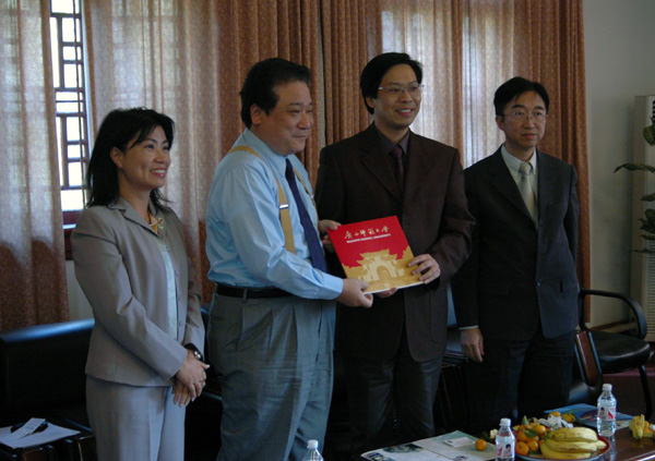刘慕仁副校长（右二）将我校的画册赠送给来访的客人。