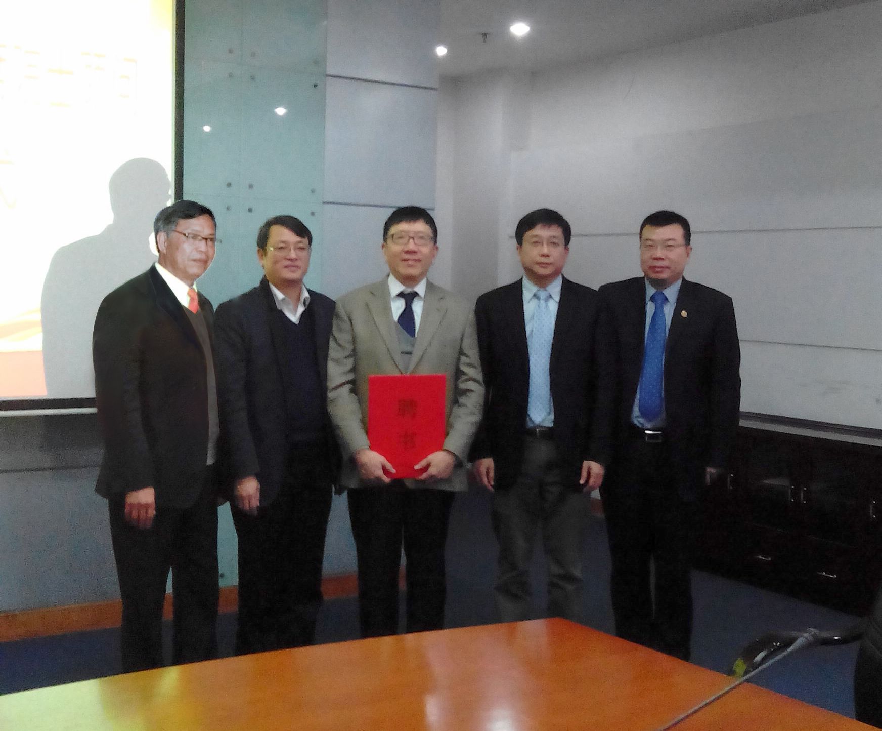 何积丰院士（左三）接受聘书