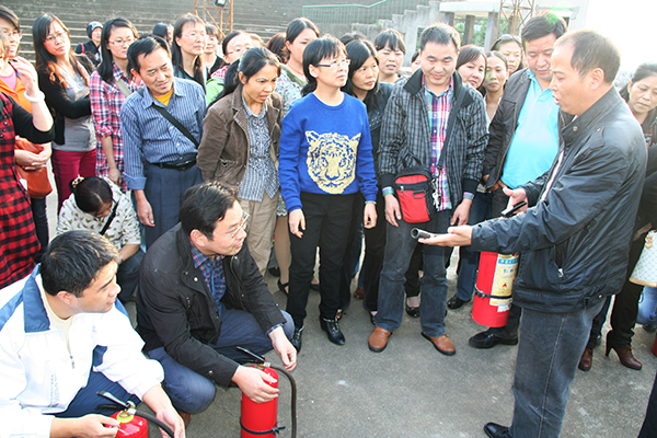 参加演练馆员认真听取学校保卫处同志介绍灭火器使用方法和初起火灾灭火技巧