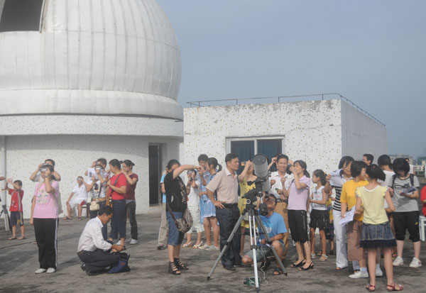 大家通过用墨镜、胶片、电焊护眼罩等方式观测百年不遇的天文奇观。