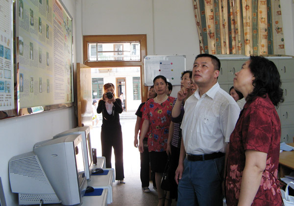 在外国语学院综合英语教研室观看巾帼文明岗位宣传栏。