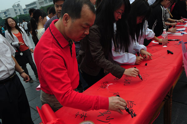 白晓军副校长和同学们一起在“节能减排，我们在行动”条幅上郑重签下了自己的名字