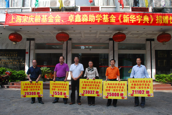 捐赠仪式现场,出版社负责人(左二)代表两家慈善组织向各县代表捐赠《新华字典》