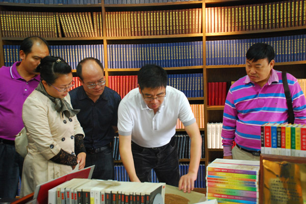 各县代表在出版社负责人陪同下参观我校出版社陈列室