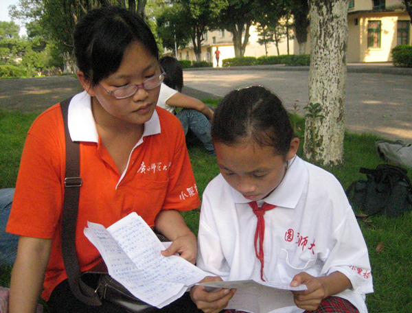 乡村留守儿童和我校小黑板志愿者在交换书信。