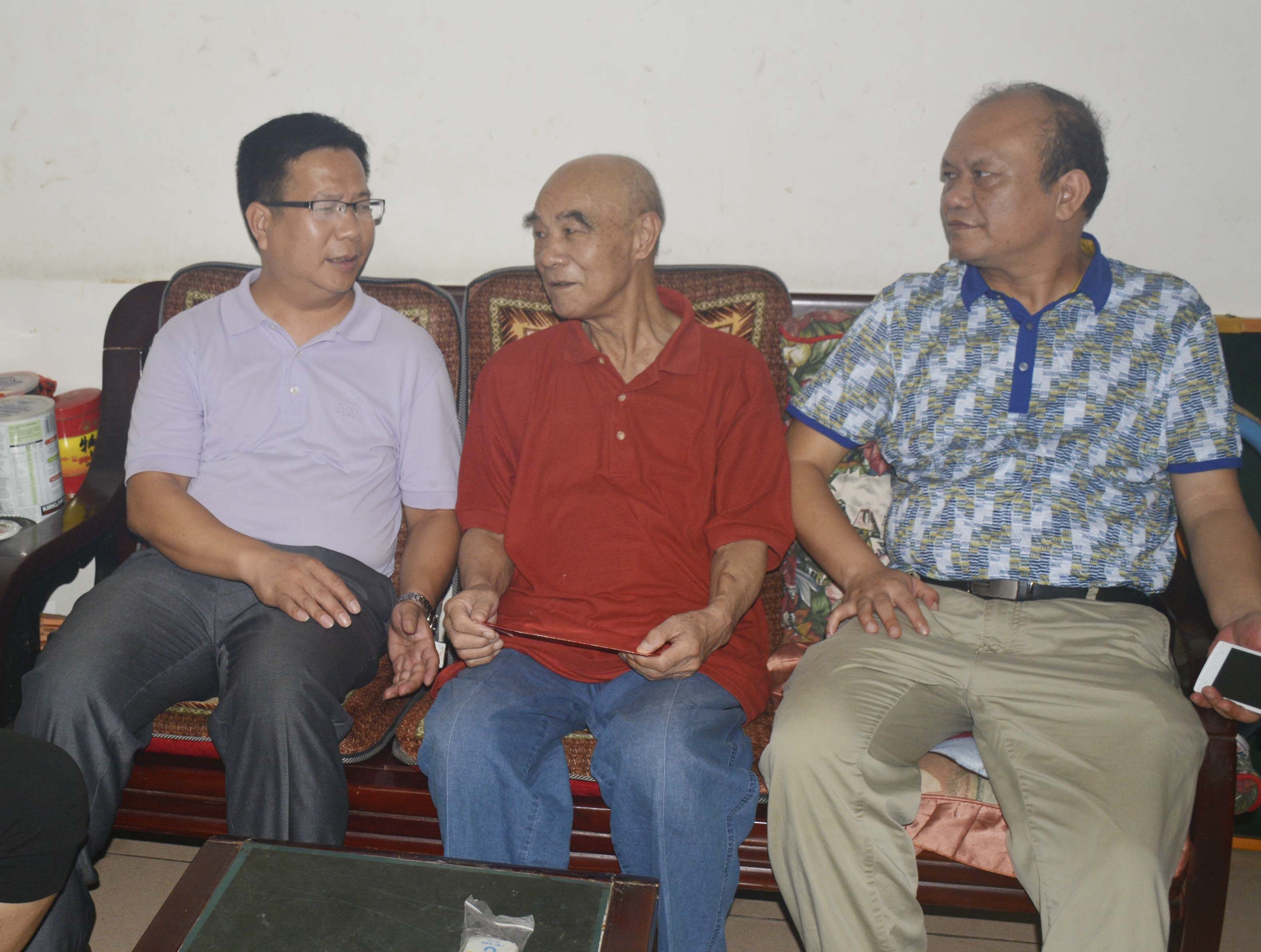 覃卫国副校长（左）在慰问时与离退休党员亲切交谈