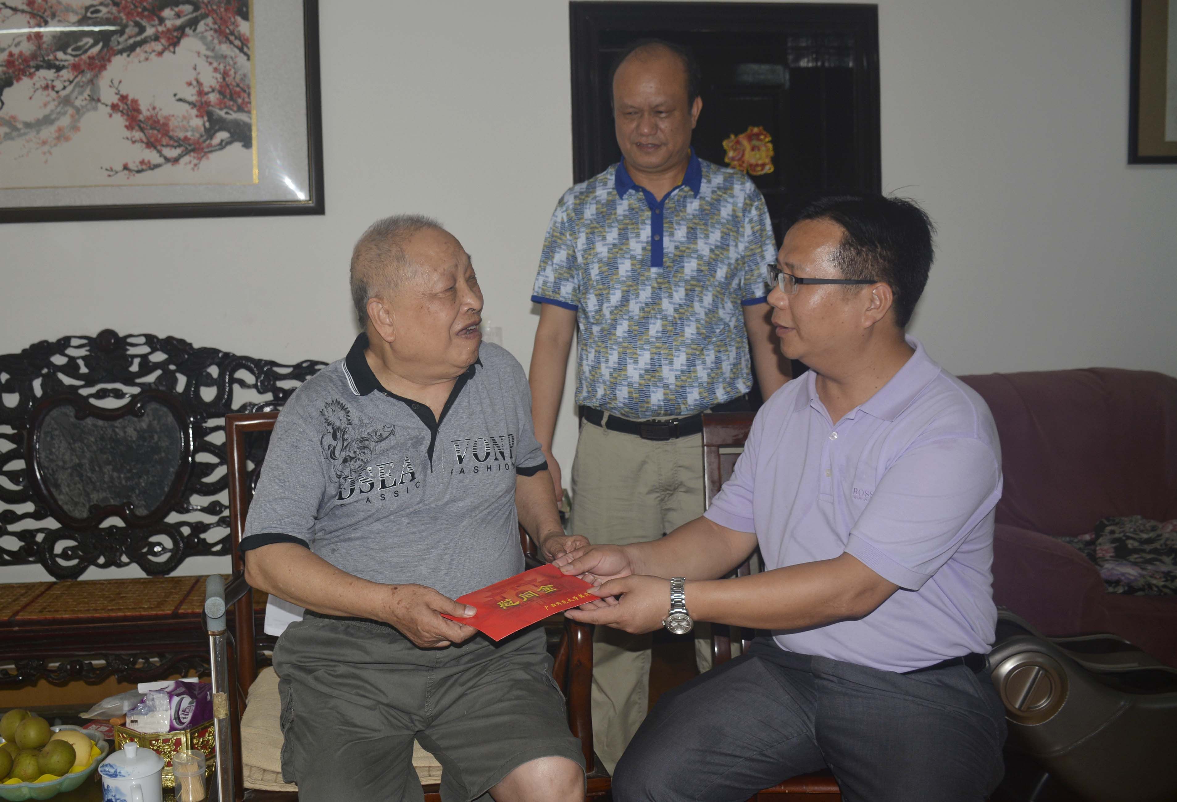 覃卫国副校长（右）在离退休党员家慰问