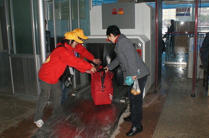 志愿者在工作岗位上为旅客提供服务