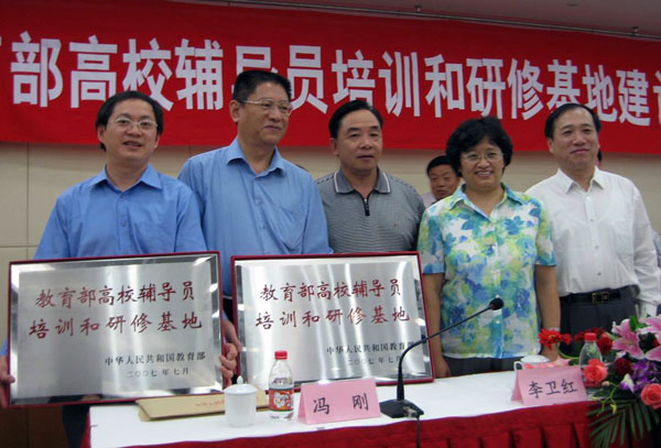 我校党委副书记唐仁郭（左一）上台领取“教育部高校辅导员培训和研修基地”牌匾。（右二为李卫红副部长，右一为杨振斌司长）