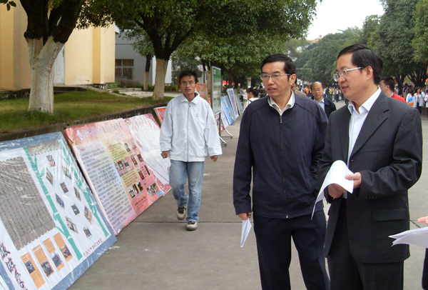 唐仁郭副书记（右一）观看研究生运动会宣传展板