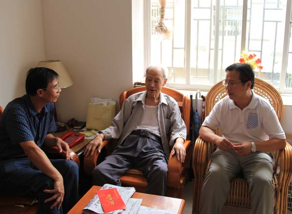覃卫国副校长（右）到离休干部家中看望慰问