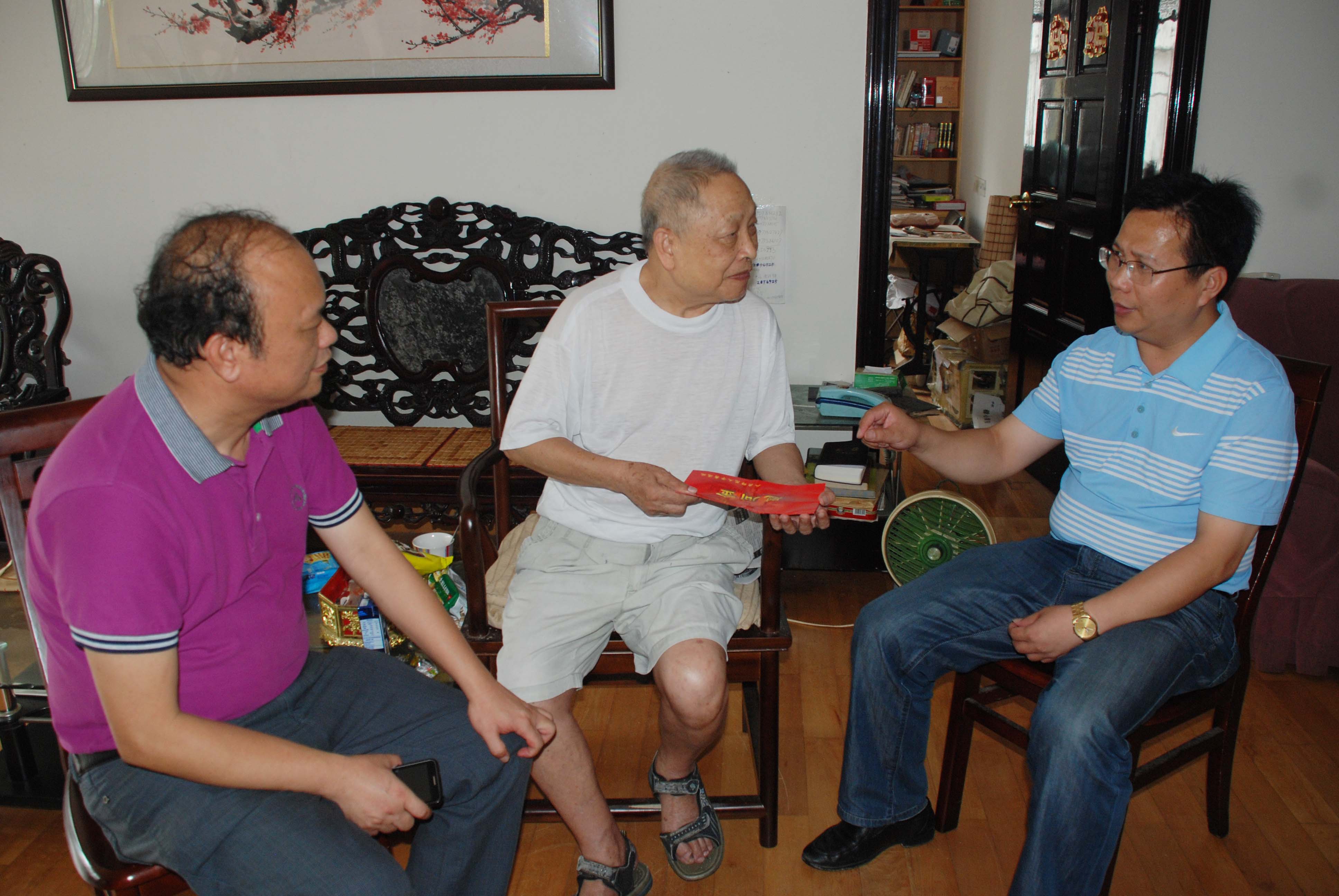 覃卫国副校长（图右）在老同志家中亲切交谈