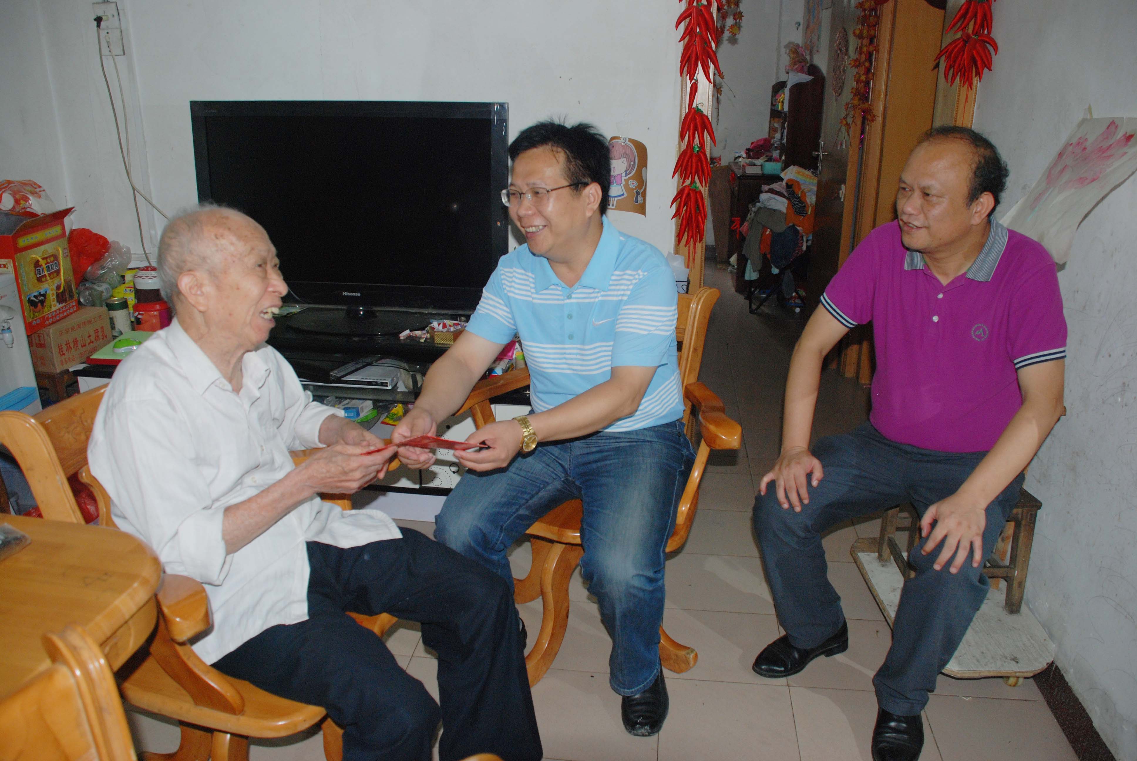 覃卫国副校长（图中）在慰问活动中与老同志亲切交谈