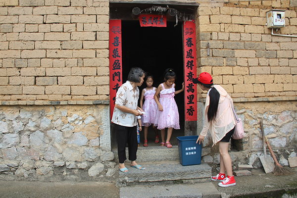 研究生干部向村民派发垃圾桶、宣传页