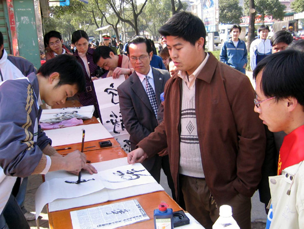 中文系的志愿者给过路群众进行即兴书法表演，并当场赠送书法。