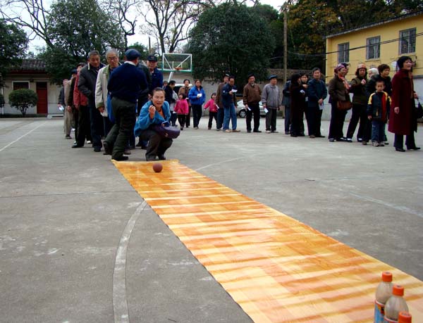 老同志在进行滚球击物