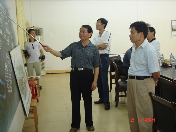 蓝常周副校长向余益中厅长(右一)介绍我校雁山校区建设情况。