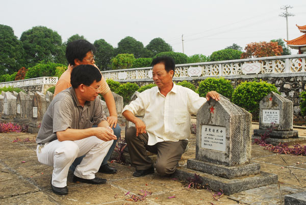 课题组成员在烈士墓前听亲历者讲述牺牲战友的情况