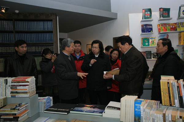 院士们饶有兴致地翻看我校出版社出版的《思考中医》《挽救中医》《中华医药学史》等图书