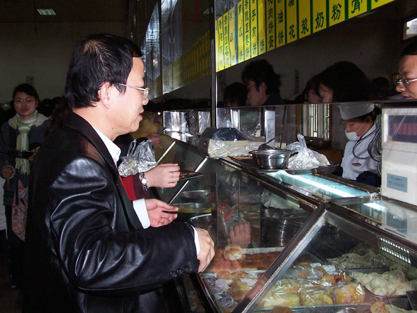 评估专家察看食堂窗口的食品供应情况。