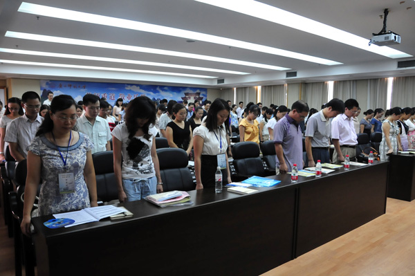 与会者全体起立，悼念甘肃舟曲遇难同胞